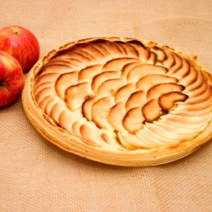 Aliment d'automne pour la santé : tarte fine aux pommes à côté de deux pommes rouges
